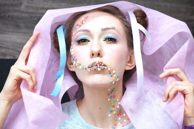 Portrait of woman wearing make-up with colorful candies