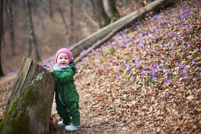 Cute toddler baby in spring forest full of wild irises. spring blossom in the forest. harmony, hope