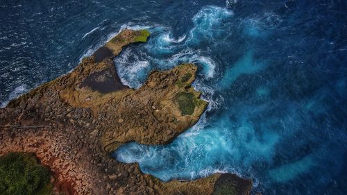 High angle view of rocks on sea shore