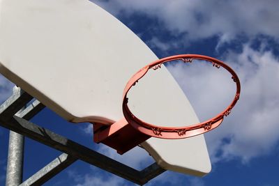 Low angle view of basketball hoop against cloudy sky