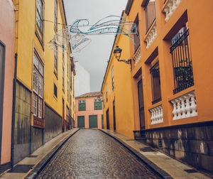 Empty road along buildings