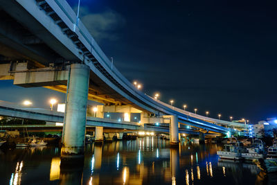 Illuminated bridge against sky at night