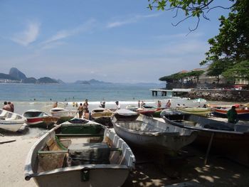 Boats moored at harbor against sky