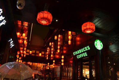 Low angle view of illuminated lanterns hanging in city at night