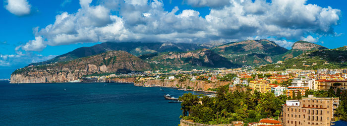 Panoramic view of city by sea against sky