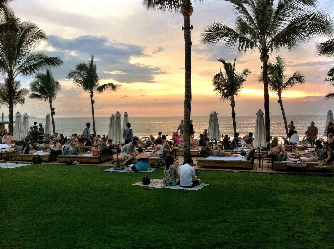 tree, sky, sunset, palm tree, sea, water, tree trunk, men, leisure activity, lifestyles, relaxation, chair, cloud - sky, person, scenics, nature, bench, sitting, tourism