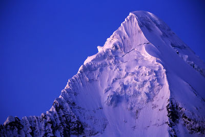 Scenic view of snow covered mountains against clear sky