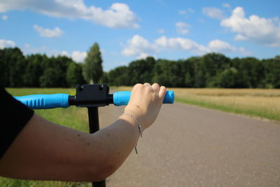 Midsection of person holding umbrella against sky