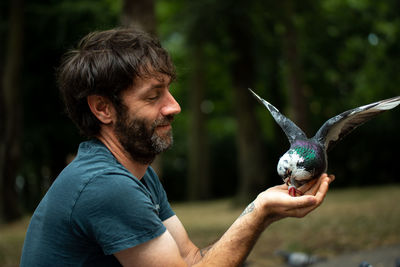 Side view of man holding bird