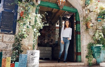 Portrait of woman standing against plants