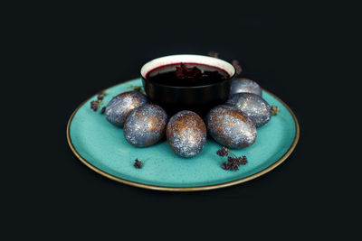 Close-up of dessert in plate against black background