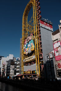 Low angle view of ferris wheel against sky in city