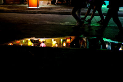 People in illuminated city at night