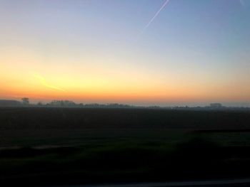 Scenic view of field against clear sky during sunset