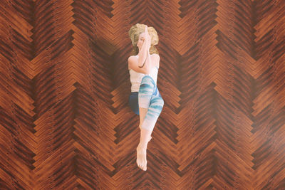 High angle view of woman exercising yoga on hardwood floor