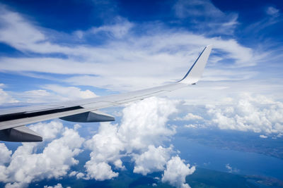 Airplane flying over clouds against blue sky