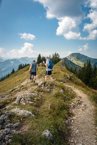 People on mountain against sky