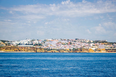 Scenic view of sea and buildings against sky