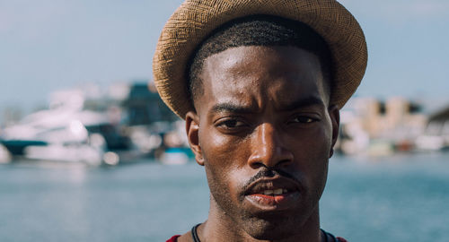 Close-up portrait of young man against sea