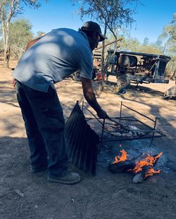 Midsection of man working on barbecue grill