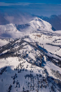 Wintery scene with snowy mountains and clouds