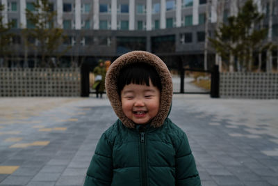 Smiling boy in warm clothing standing outdoors