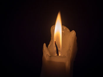 Close-up of illuminated candle against black background