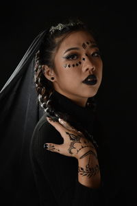 Portrait of a beautiful young woman over black background