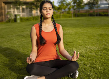 Portrait of young woman sitting on field
