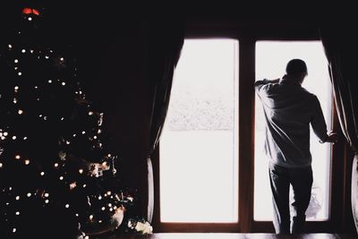 Man standing by window at home