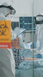 Rear view of doctor examining patient in hospital