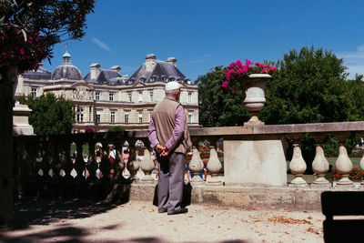 People standing by flowering plants against sky