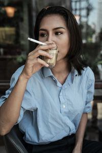 Portrait of woman drinking drink in restaurant