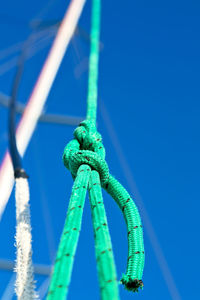 Close-up of rope tied on metal against blue sky