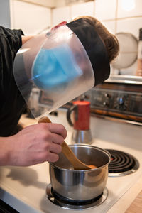 Midsection of man working in kitchen at home