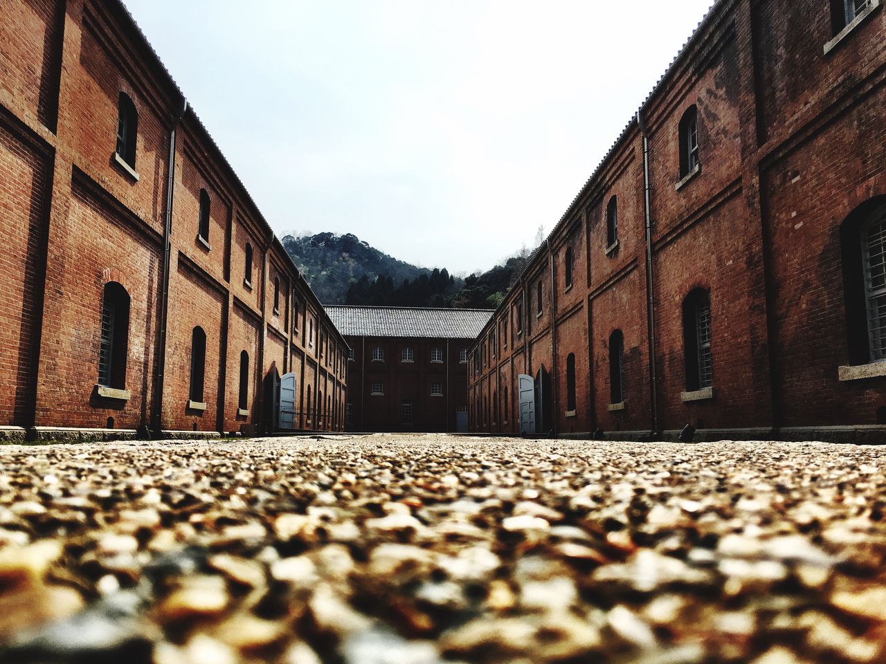 architecture, surface level, built structure, building exterior, the way forward, diminishing perspective, sky, cobblestone, street, road, empty, house, vanishing point, day, long, selective focus, outdoors, no people, clear sky, residential structure