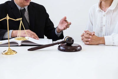 Midsection of lawyers discussing at desk in courthouse