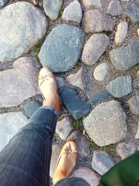 Low section of person standing on pebbles