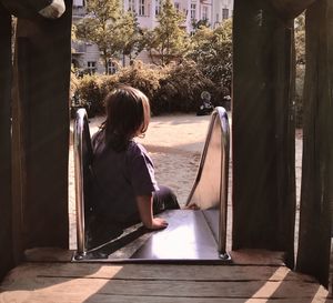 Rear view of woman looking through window