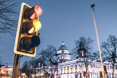 Low angle view of illuminated street light against sky