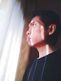 Young man looking through window