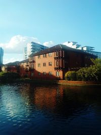 Houses by river against sky