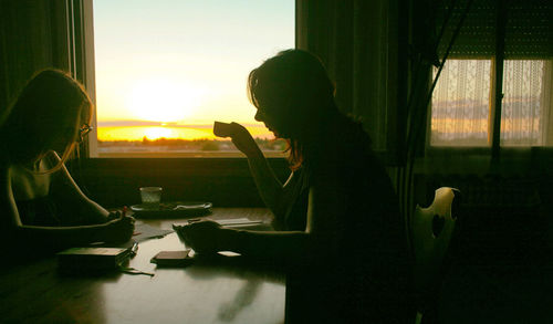 People sitting on table by window