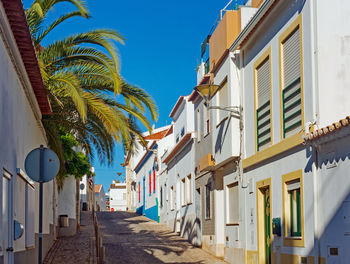 Narrow street amidst buildings against clear sky