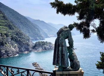 Statue by sea against sky