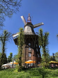 Low angle view of traditional windmill against clear blue sky