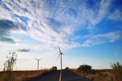 Road amidst field against sky