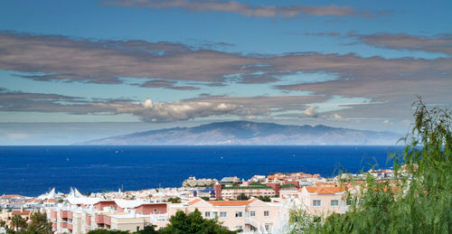 High angle view of houses by sea against sky