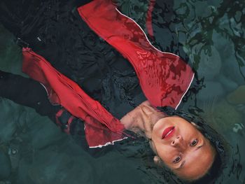 High angle portrait of woman lying in water