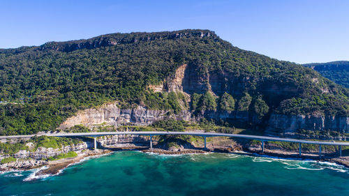 View of swimming sea cliff bridge against mountain